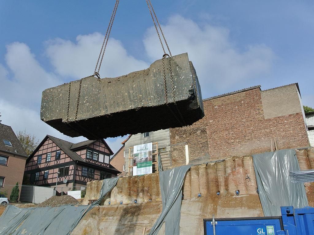 Ein großer Betonblock wird von einem Kran angehoben