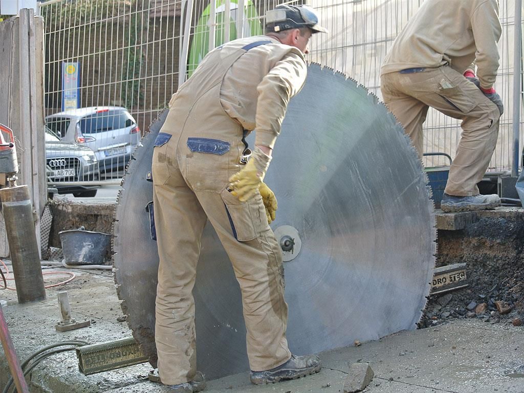 Ein Mann schneidet Beton mit einer großen Kreissäge