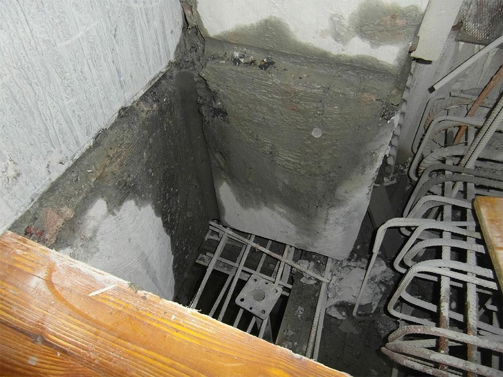 Ein Loch in einer Wand, durch das eine Treppe nach unten führt