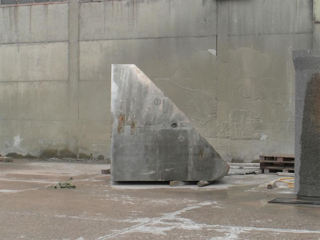 Ein großes Metallobjekt liegt vor einer Betonwand