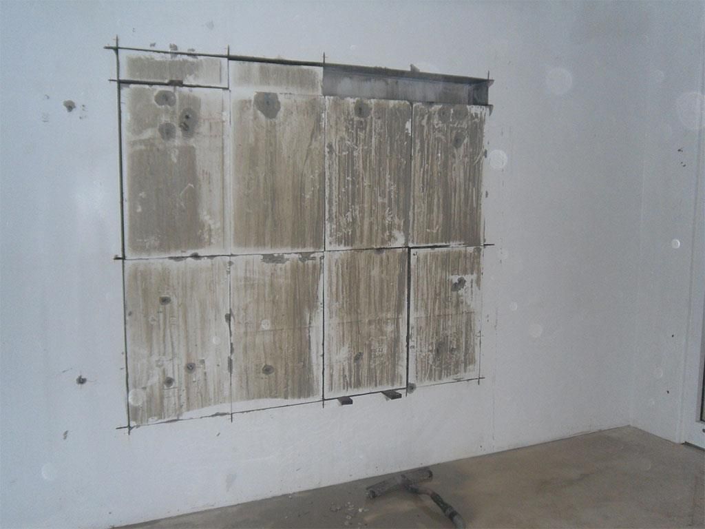 Eine weiße Wand mit einem Loch darin, das wie ein Fenster aussieht