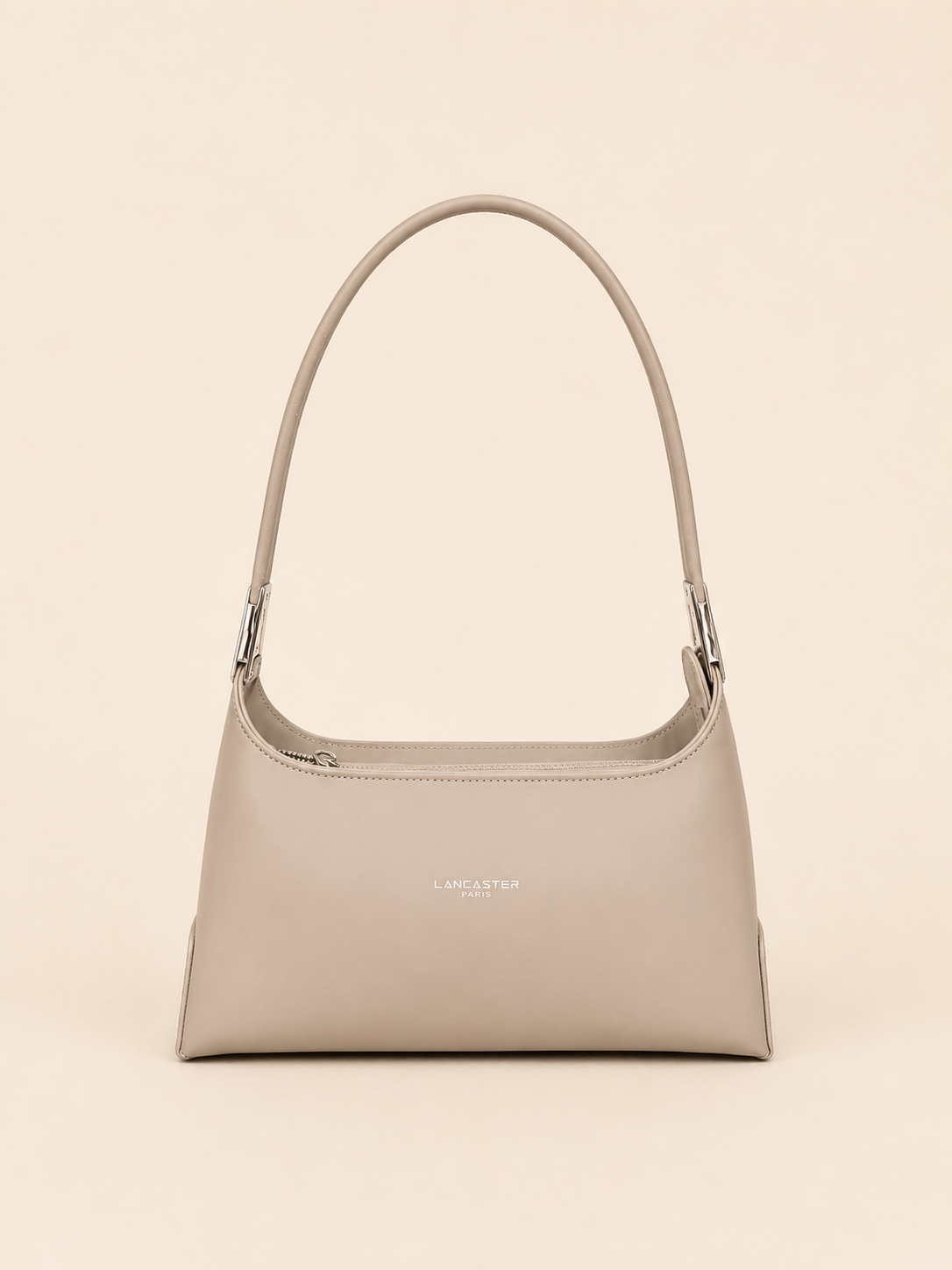 Sac à main bandoulière beige avec une bandoulière incurvée sur fond beige uni