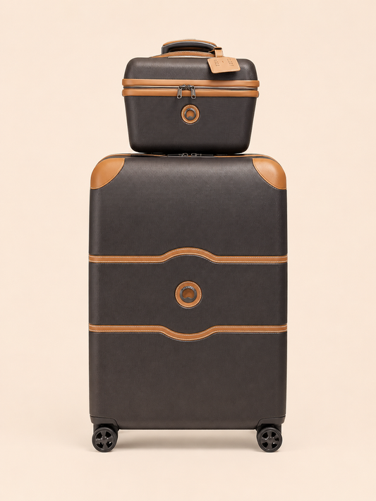 Valise rigide noire avec finitions beige et une petite valise assortie empilée dessus.