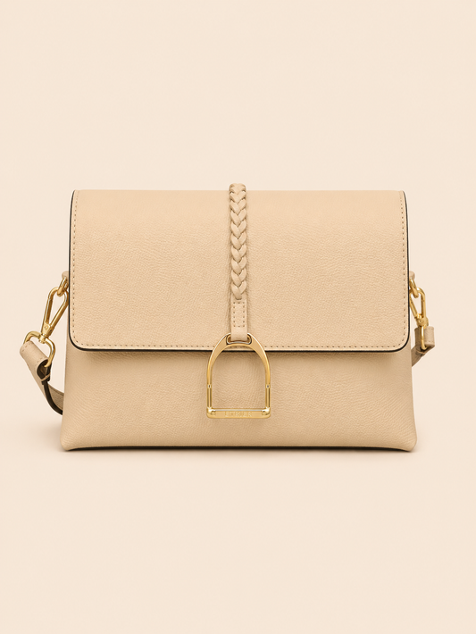 Sac à main en cuir beige avec fermoir et chaînette dorés sur fond beige uni