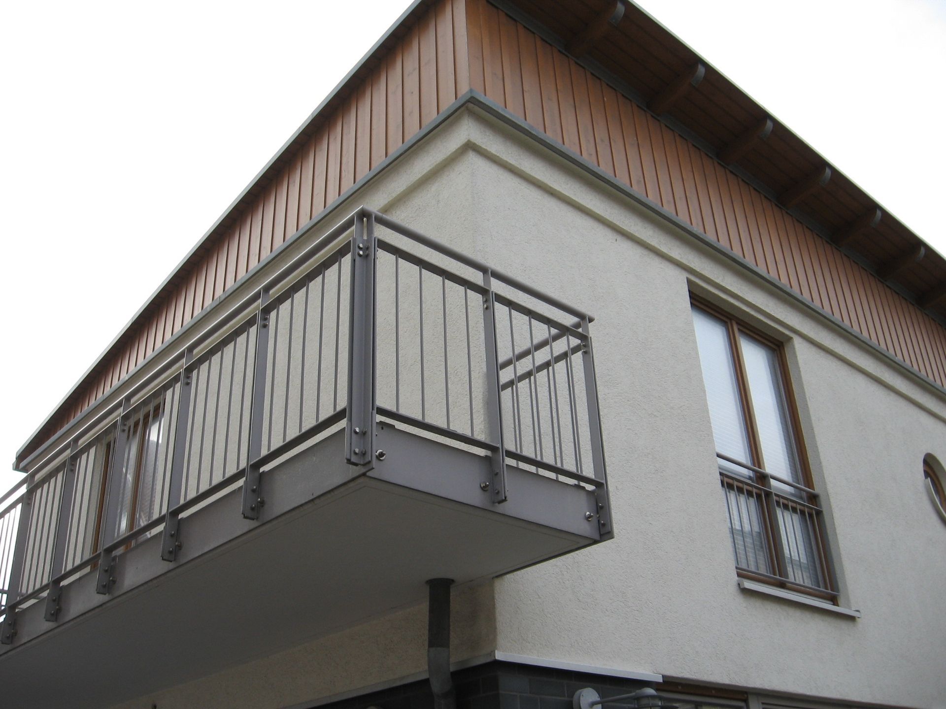 ein weißes Haus mit einem Balkon und zwei Fenstern