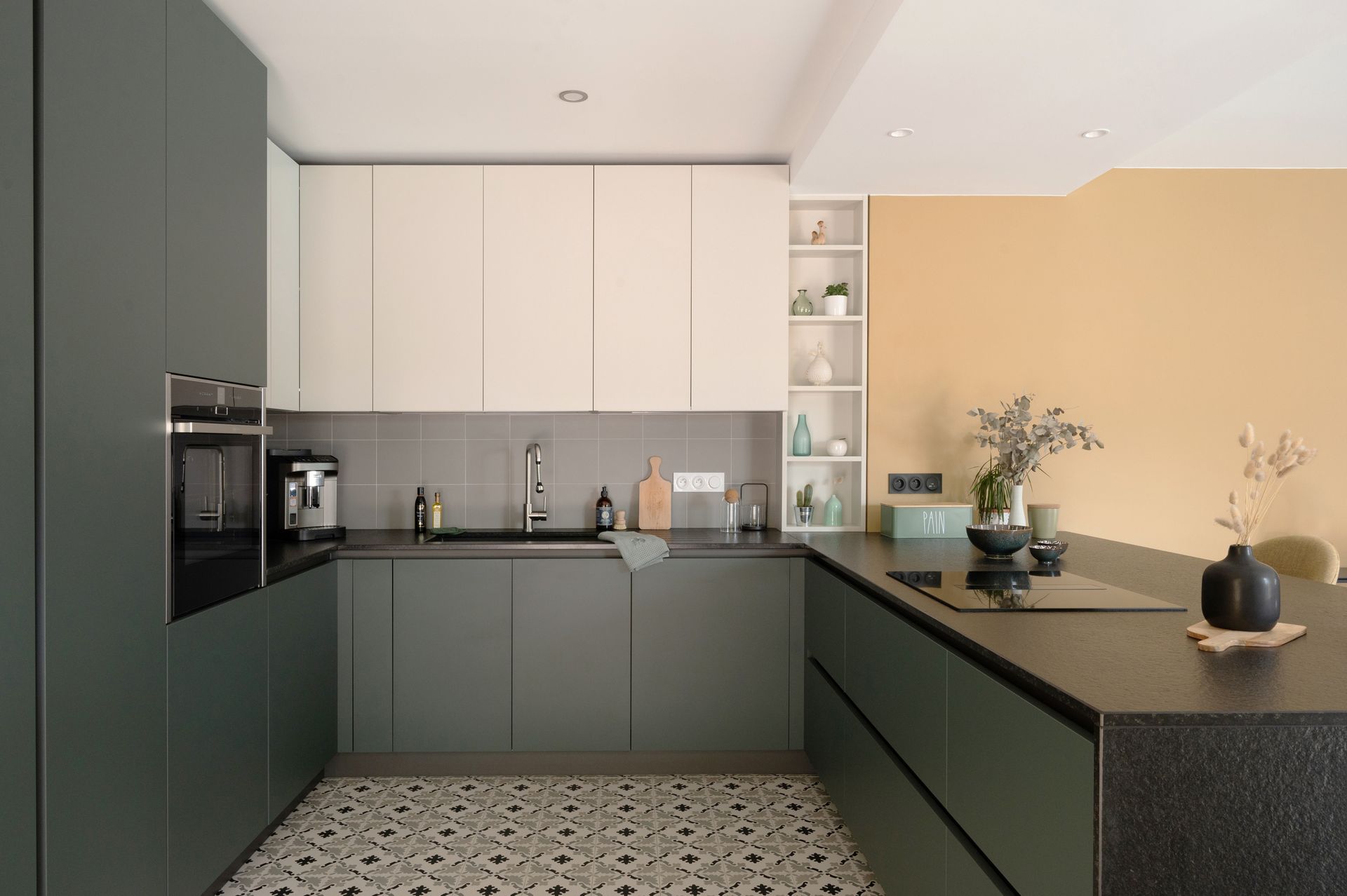 Cuisine moderne avec placards vert foncé, placards hauts blancs et mur jaune.