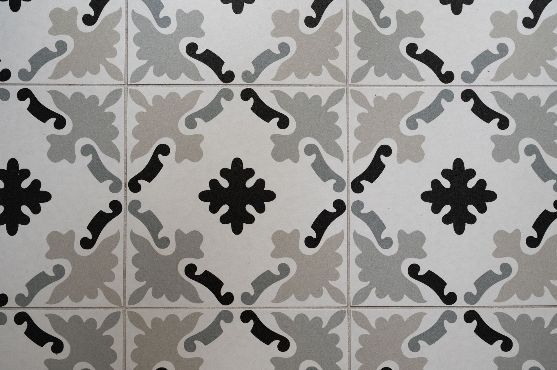 Motif de carreaux décoratifs : motif floral blanc, gris et noir.