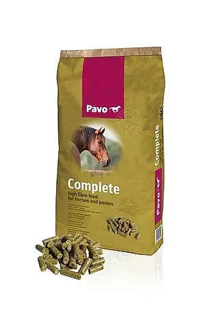 Bolsa de pienso para caballos Pavo con gránulos derramados a su lado sobre un fondo blanco.