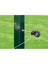 Aislador de cerca eléctrica sujeto a un poste de cerca verde en un campo de hierba.