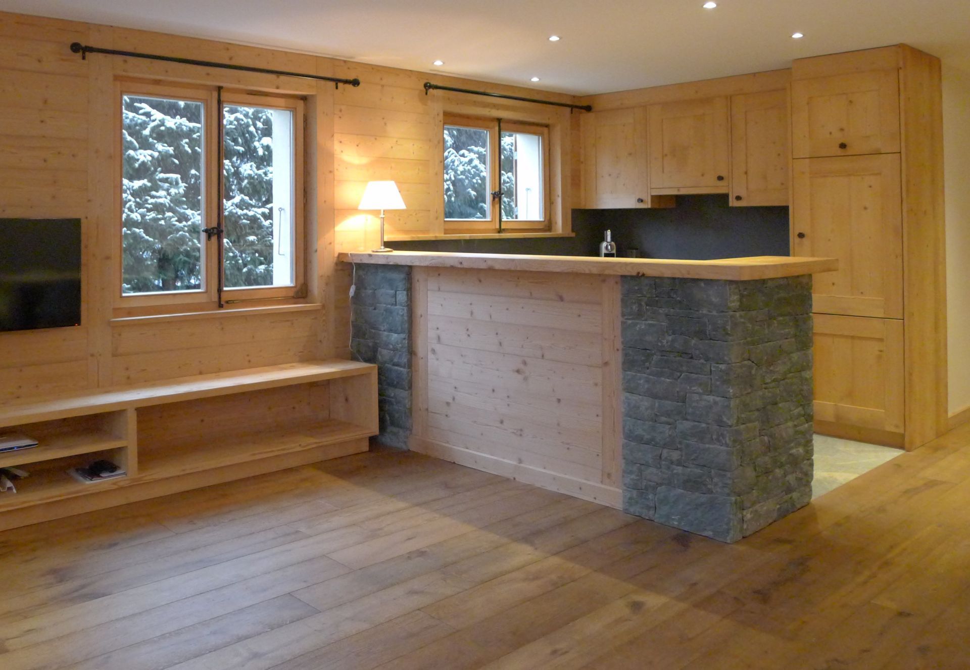 Un salon avec des armoires en bois et une télévision