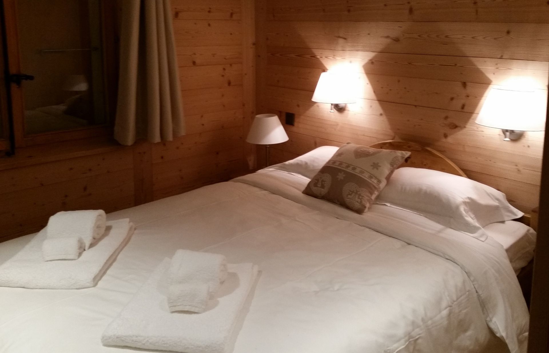 Une chambre avec un lit et deux lampes au mur