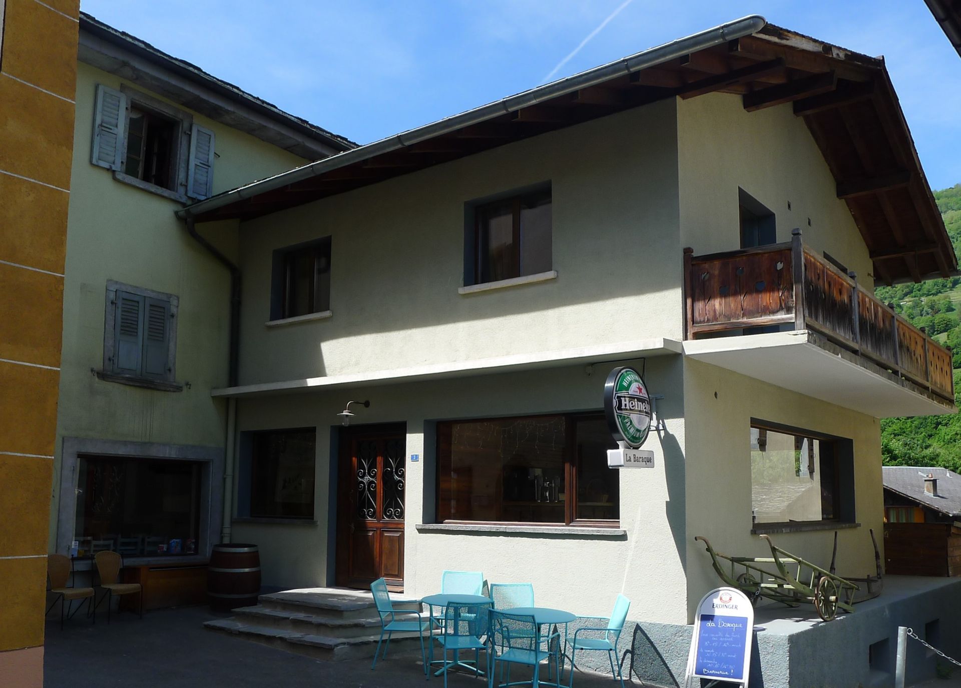 Une grande maison avec un balcon et des tables et des chaises à l'extérieur
