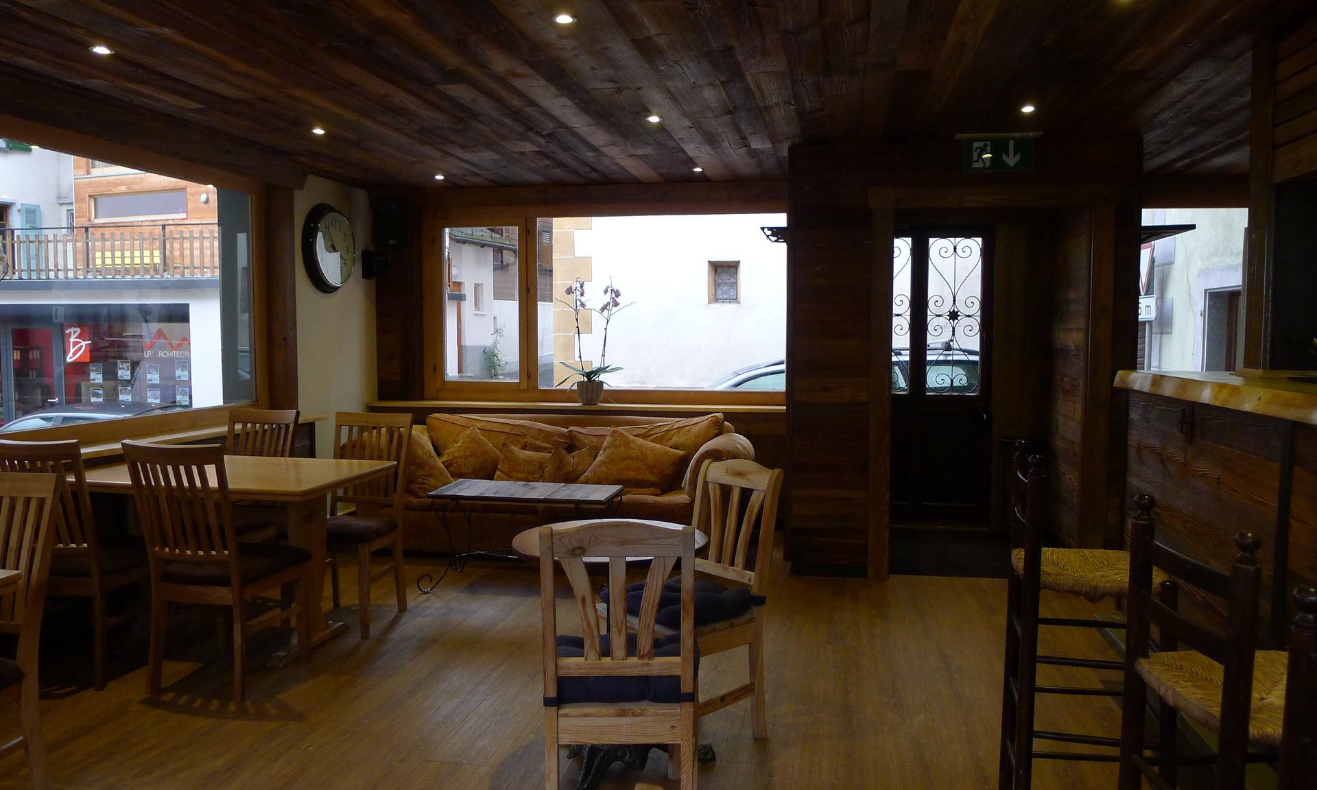 Une pièce avec des tables et des chaises et une horloge sur le mur