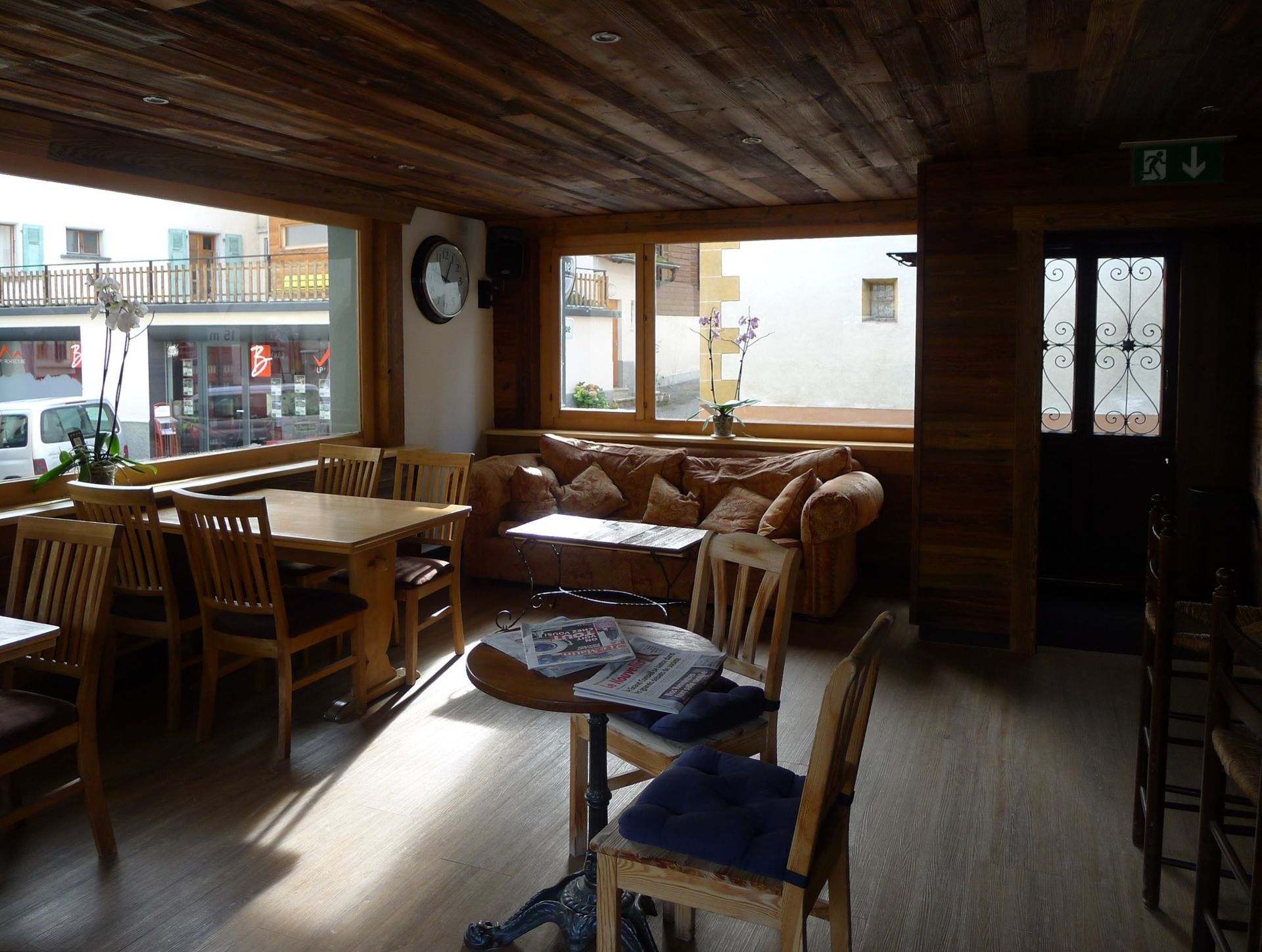 Une pièce avec des tables et des chaises et une horloge sur le mur