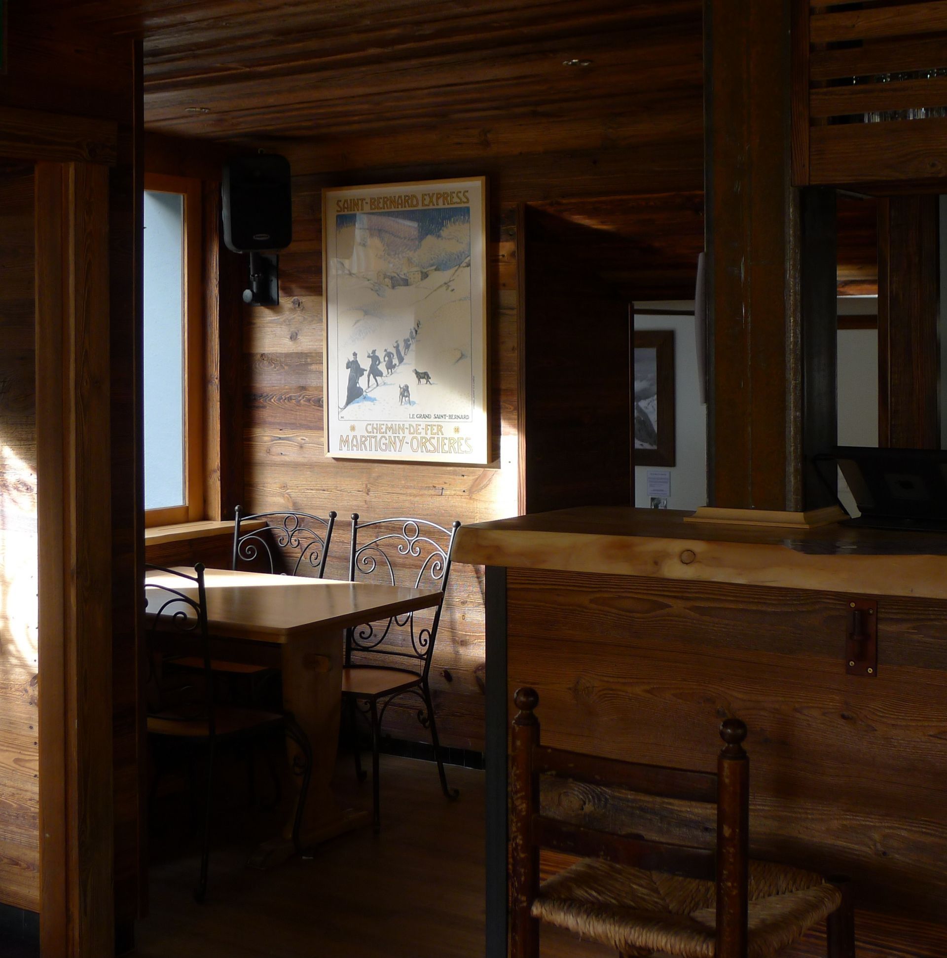Une pièce avec une table et des chaises et une affiche sur le mur