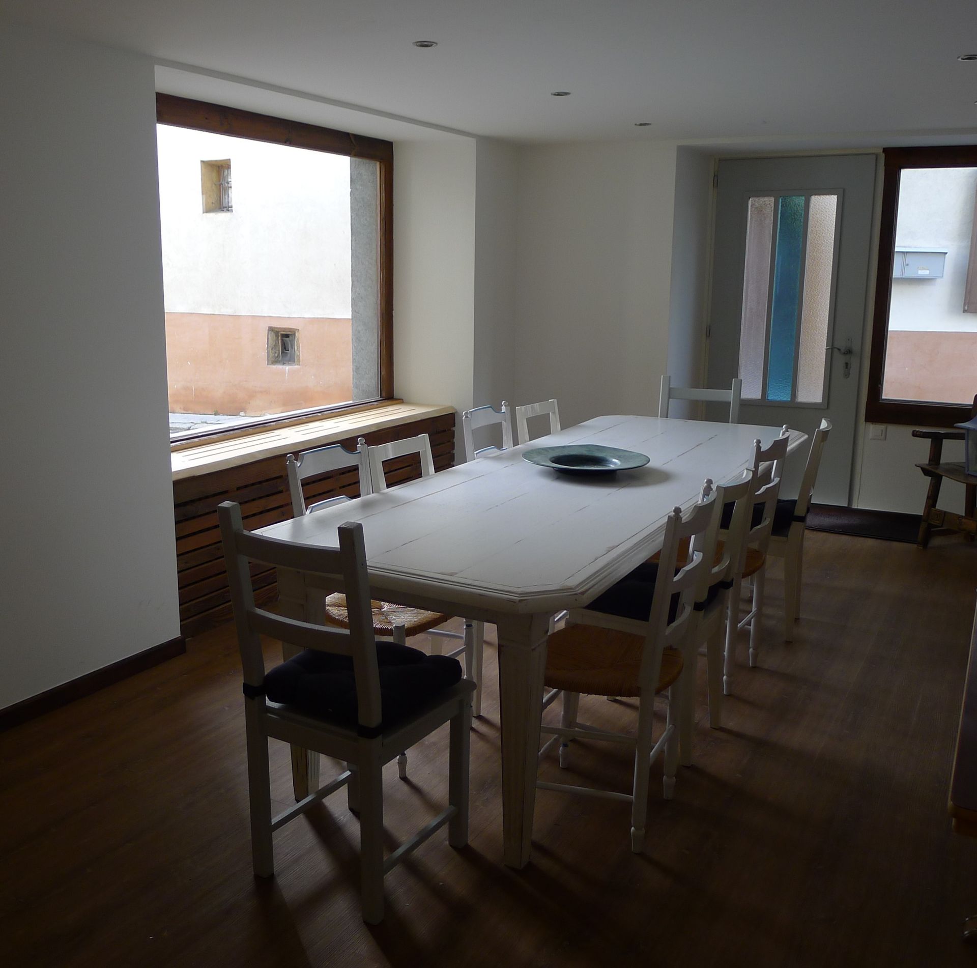 Une salle à manger avec une table et des chaises et une fenêtre