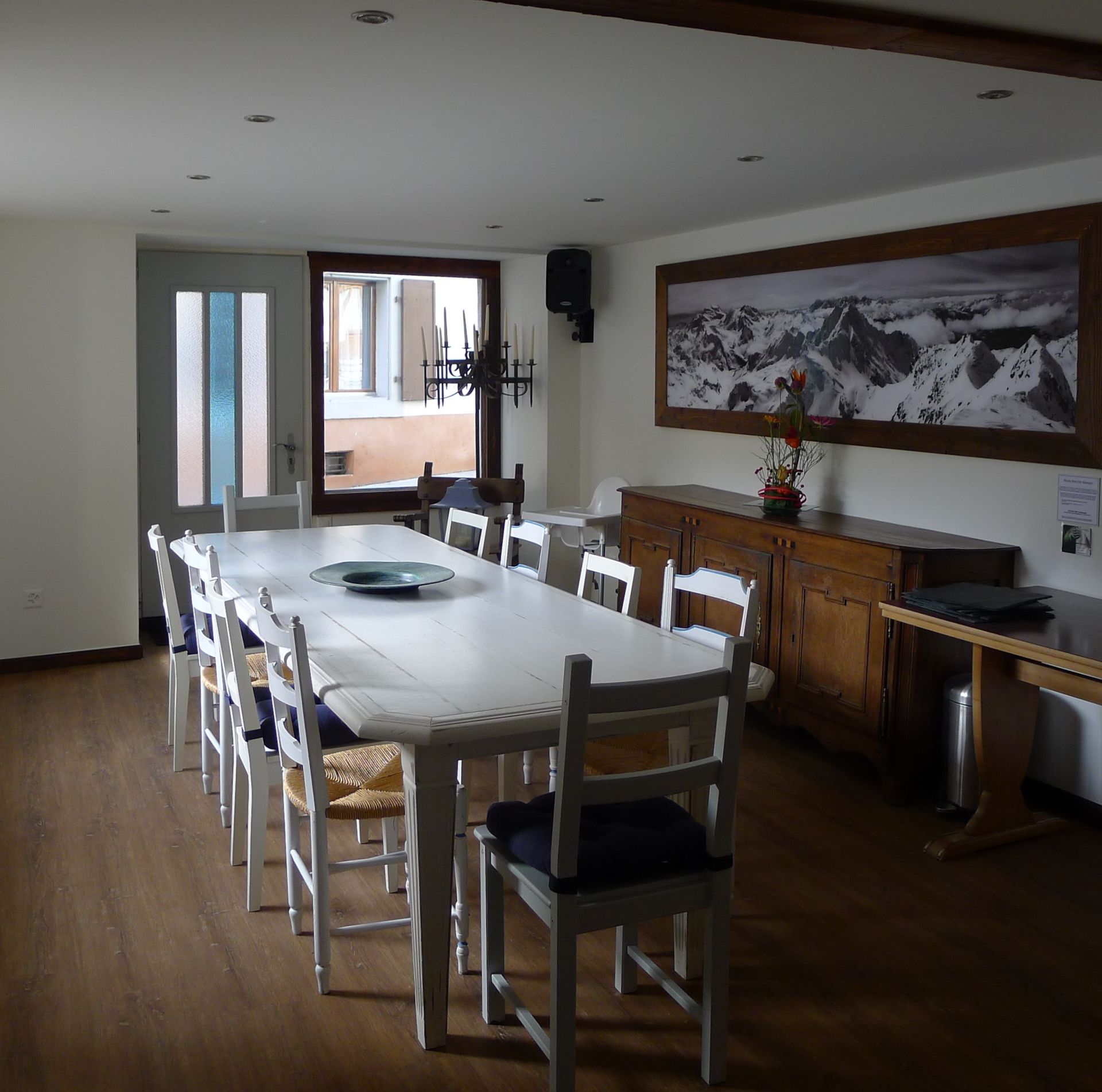 Une salle à manger avec une longue table blanche et des chaises