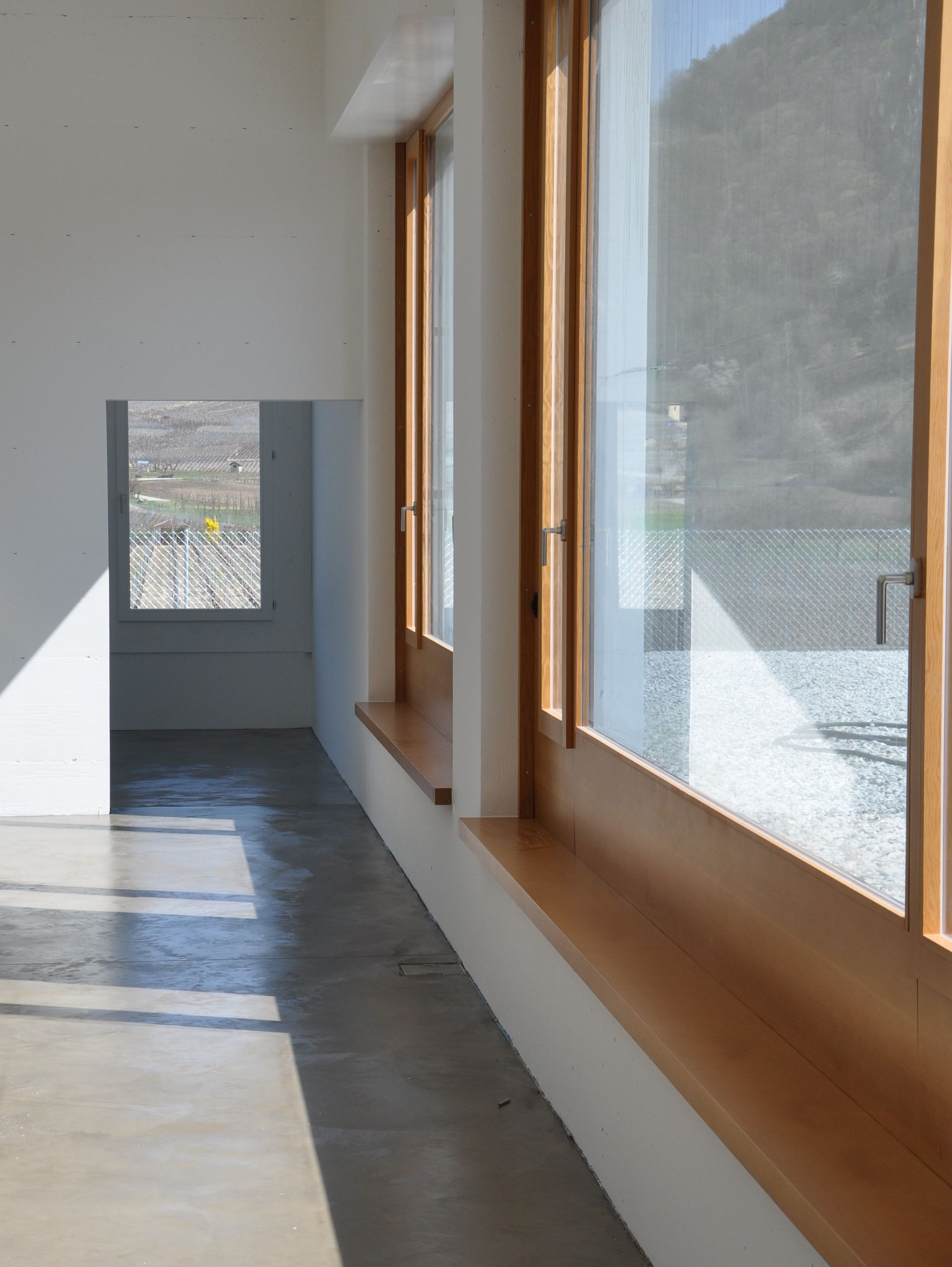 Un couloir avec beaucoup de fenêtres et un sol en béton