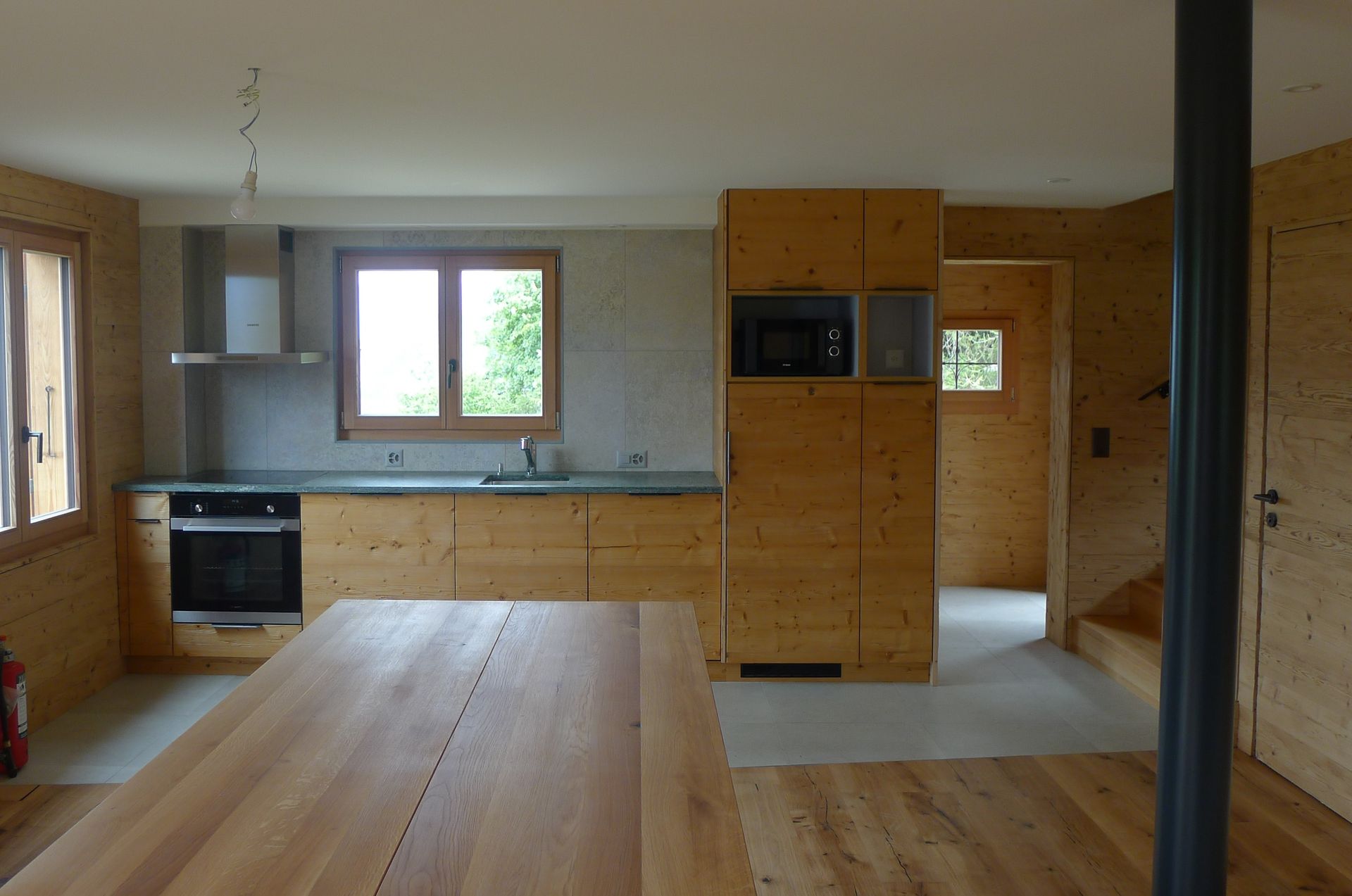 Une cuisine avec des armoires en bois et une table en bois