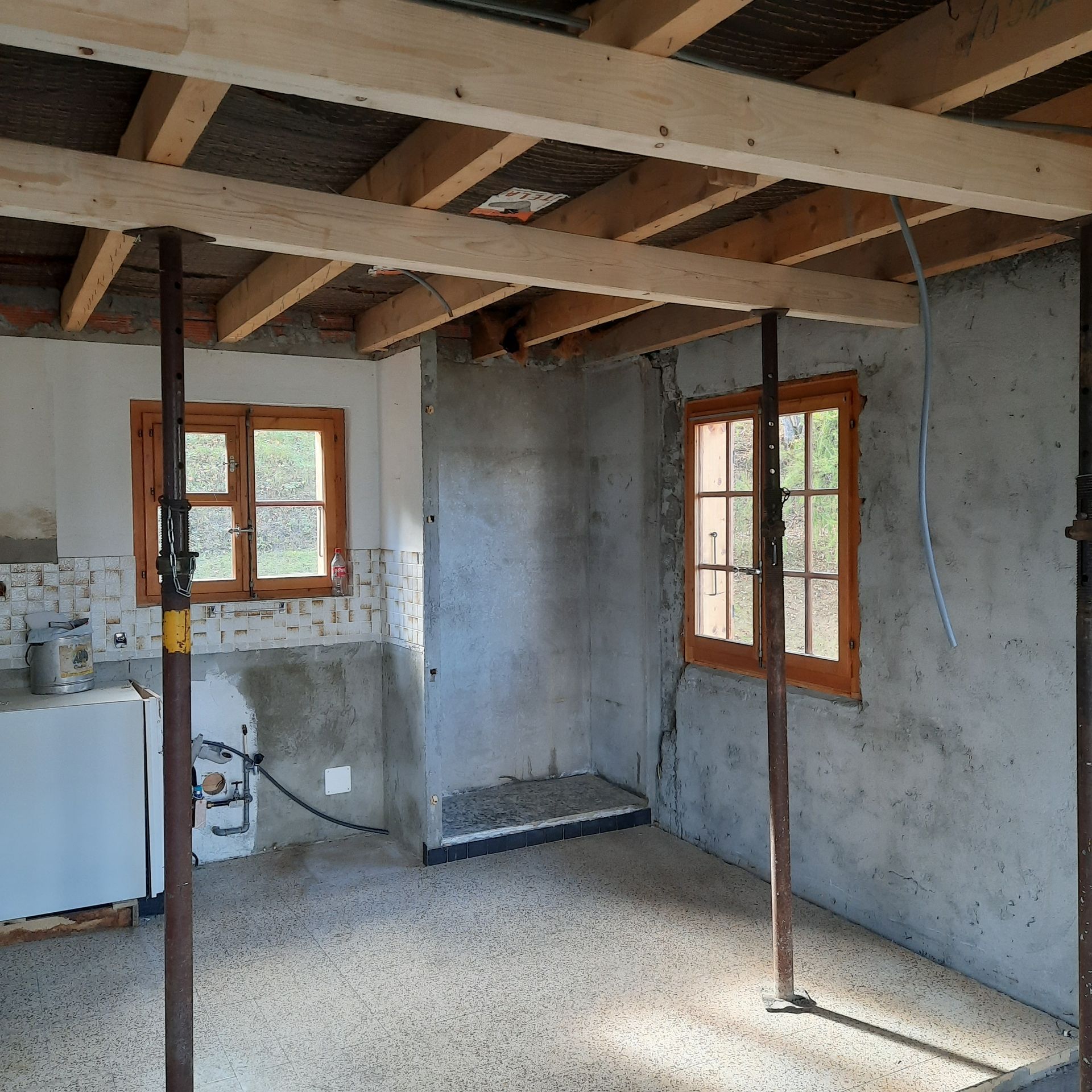 Une pièce avec un plafond en bois et quelques fenêtres