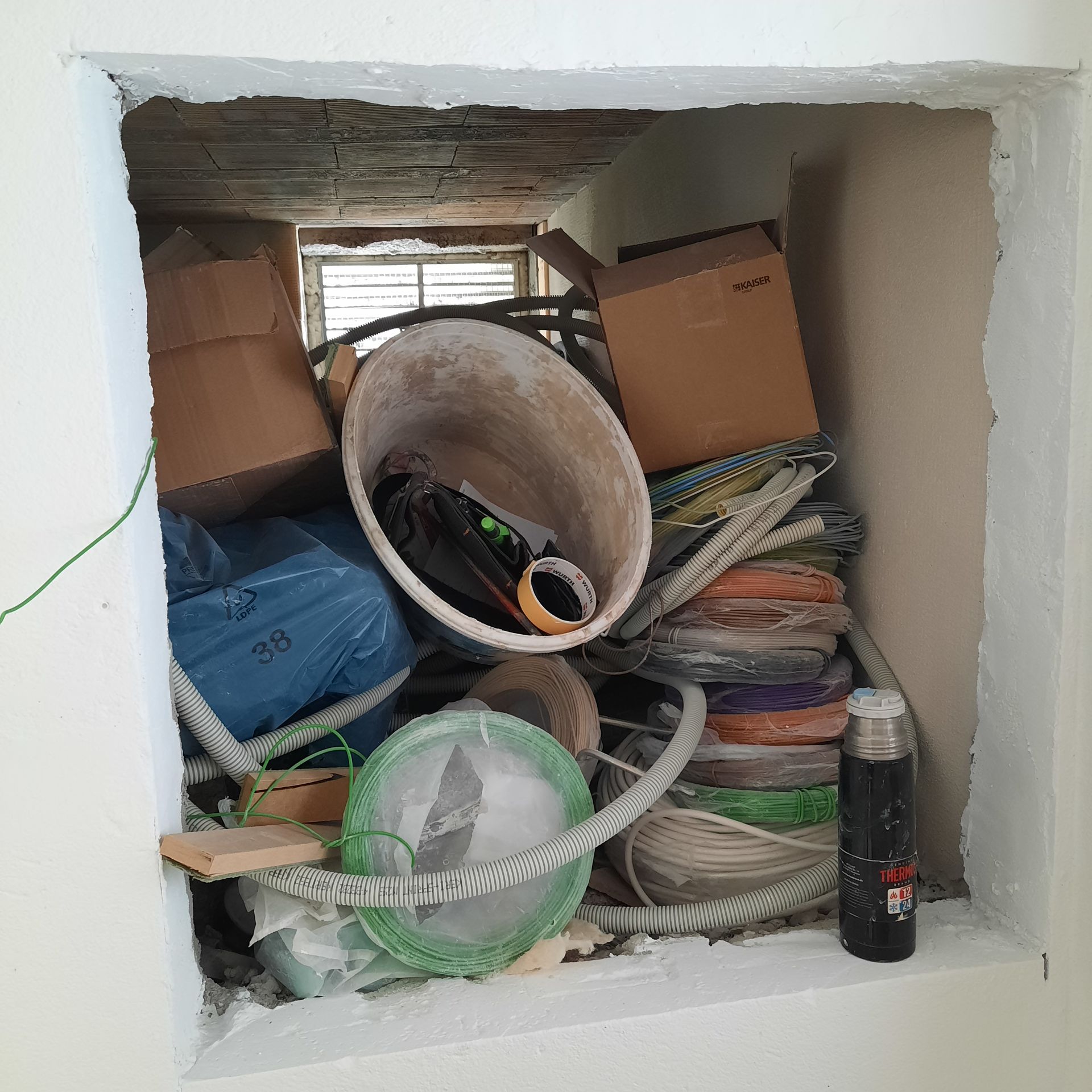 Une pièce avec beaucoup de déchets et un briquet sur le sol