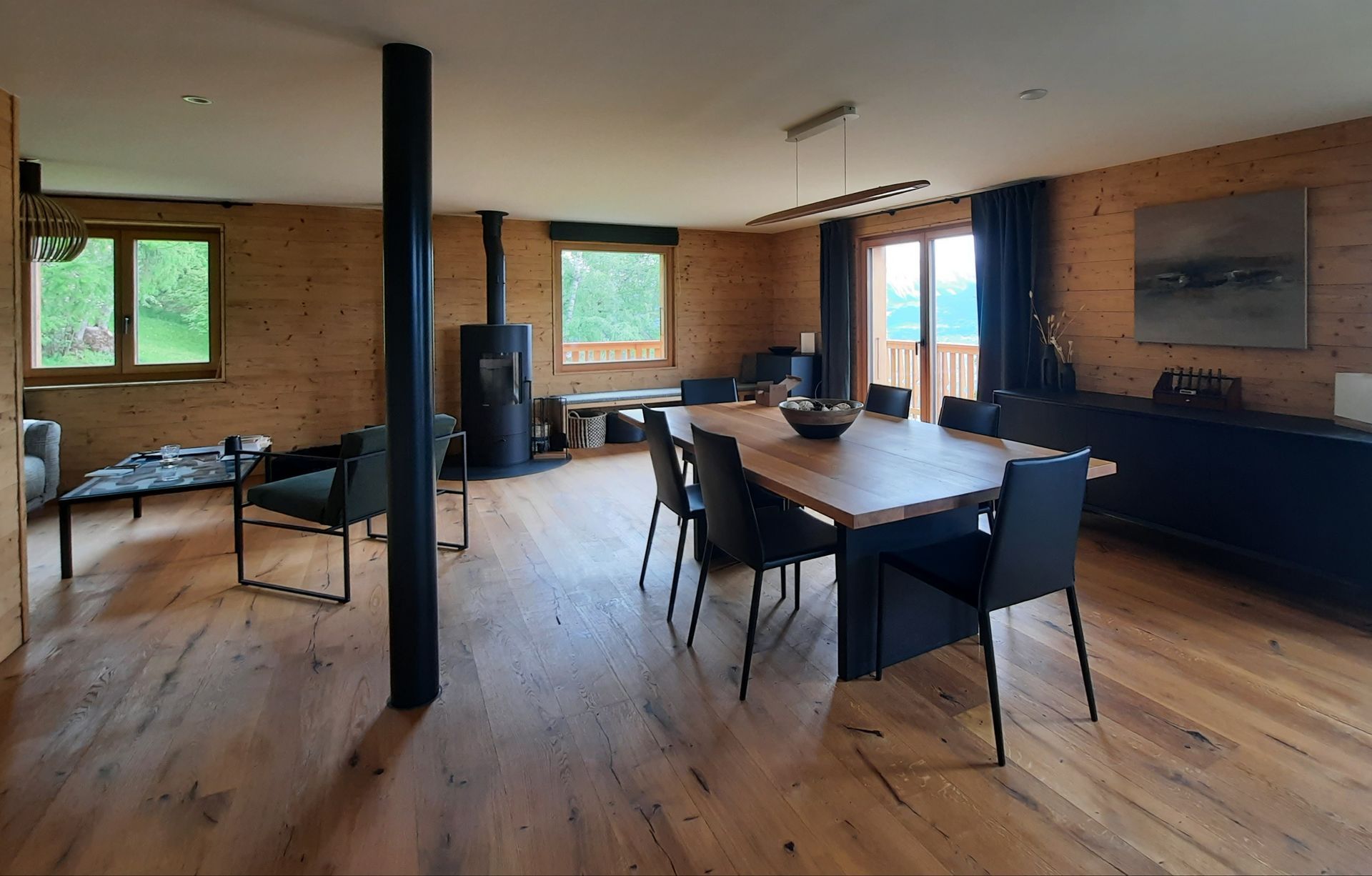 Une grande pièce avec une table et des chaises en bois