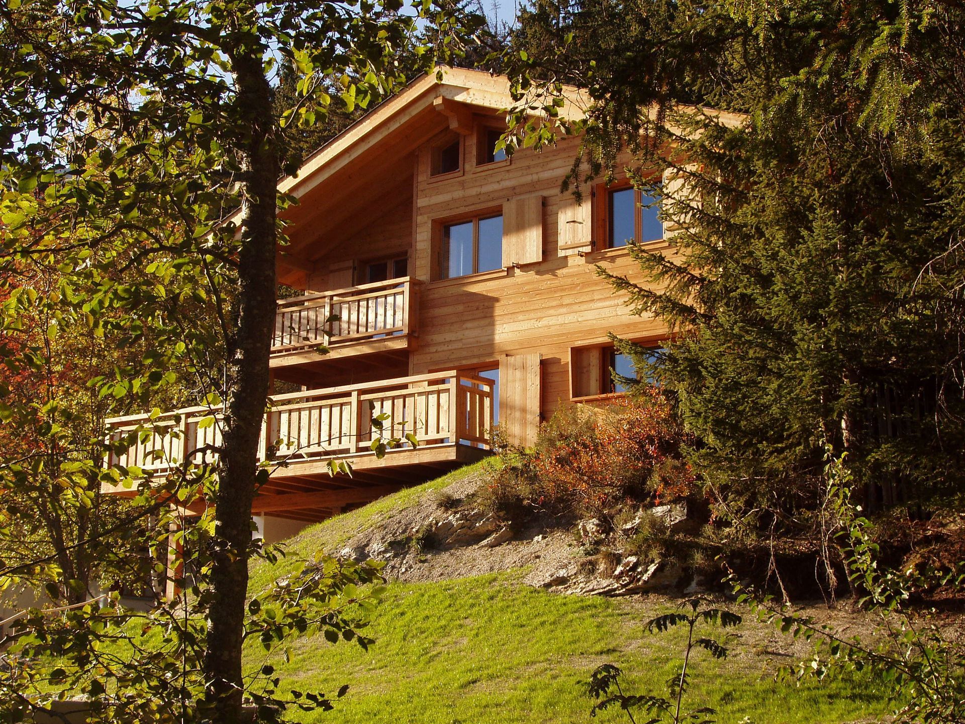 Une grande maison en bois est entourée d'arbres et d'herbe