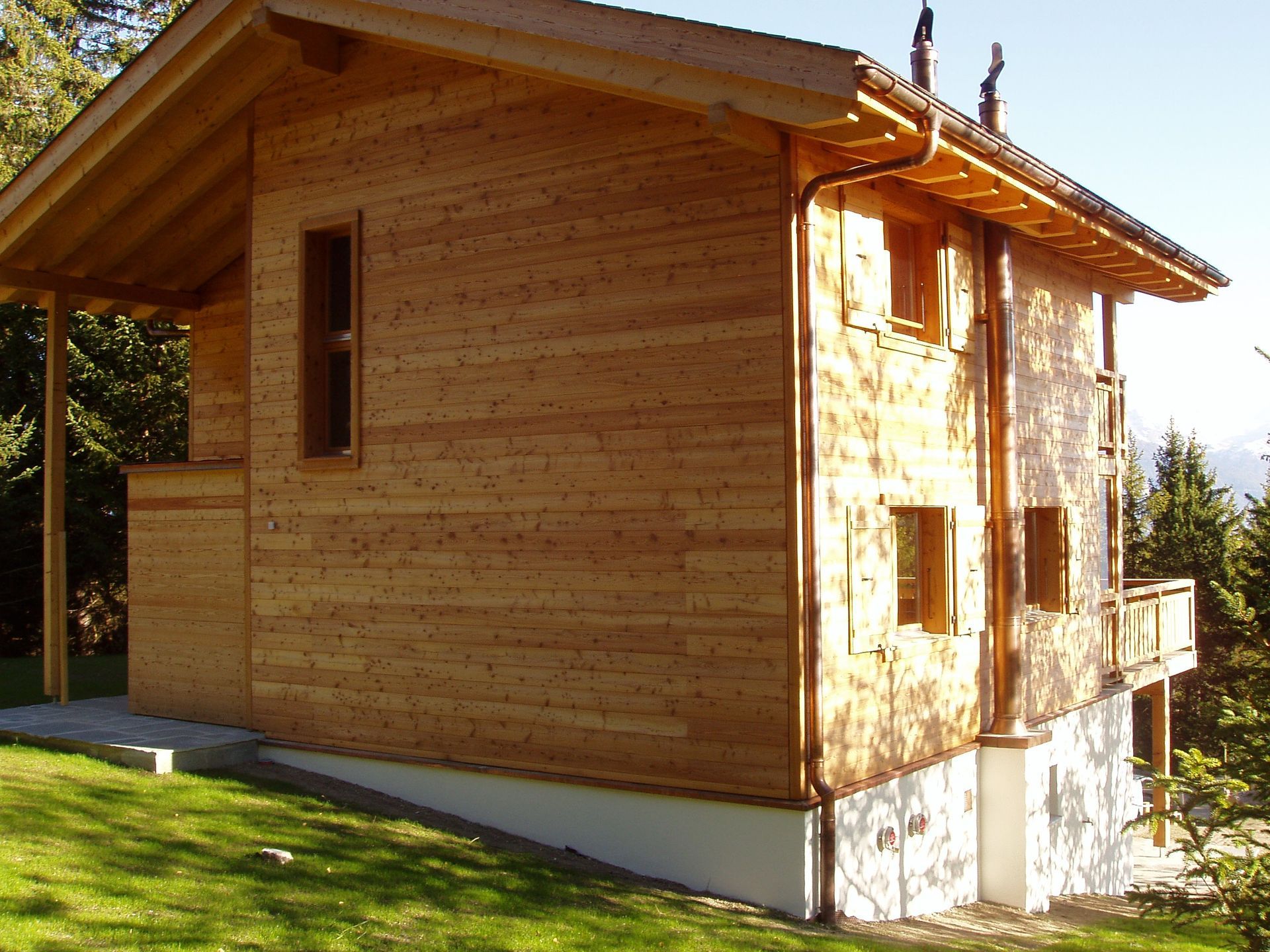 Une petite maison en bois avec un tuyau en cuivre sur le côté