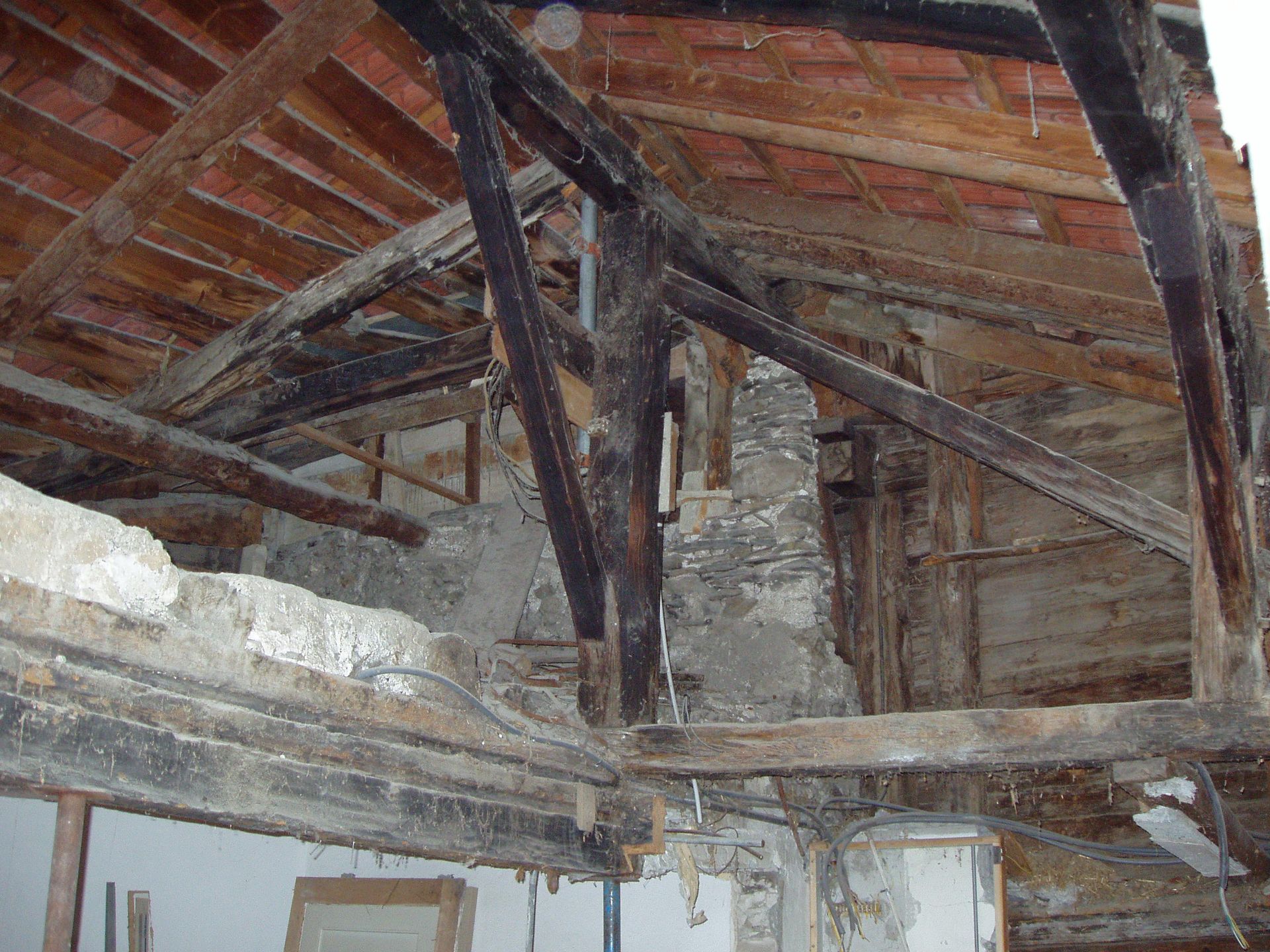 Une structure en bois avec un toit en brique en arrière-plan