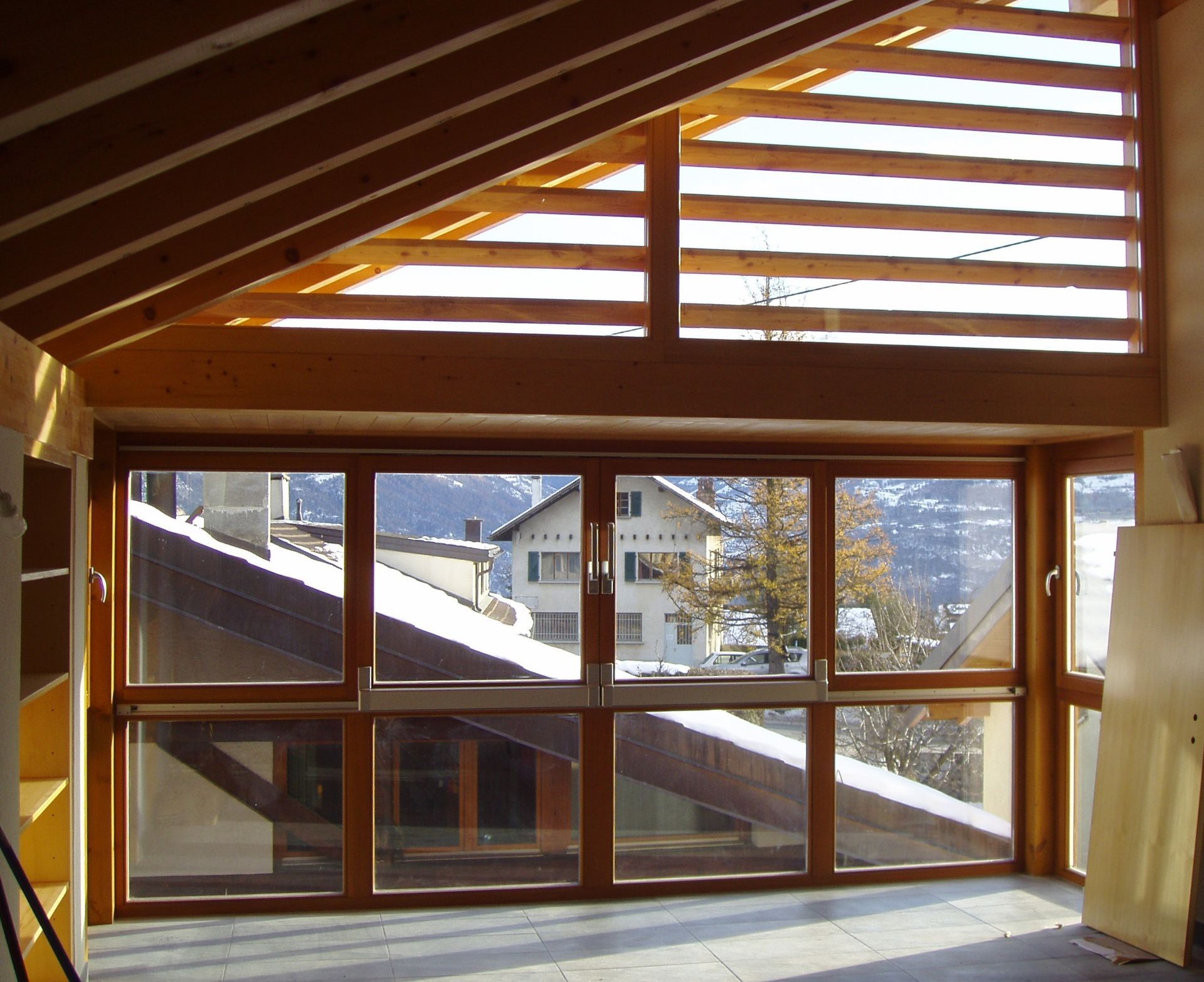 Une pièce avec beaucoup de fenêtres et un toit en bois