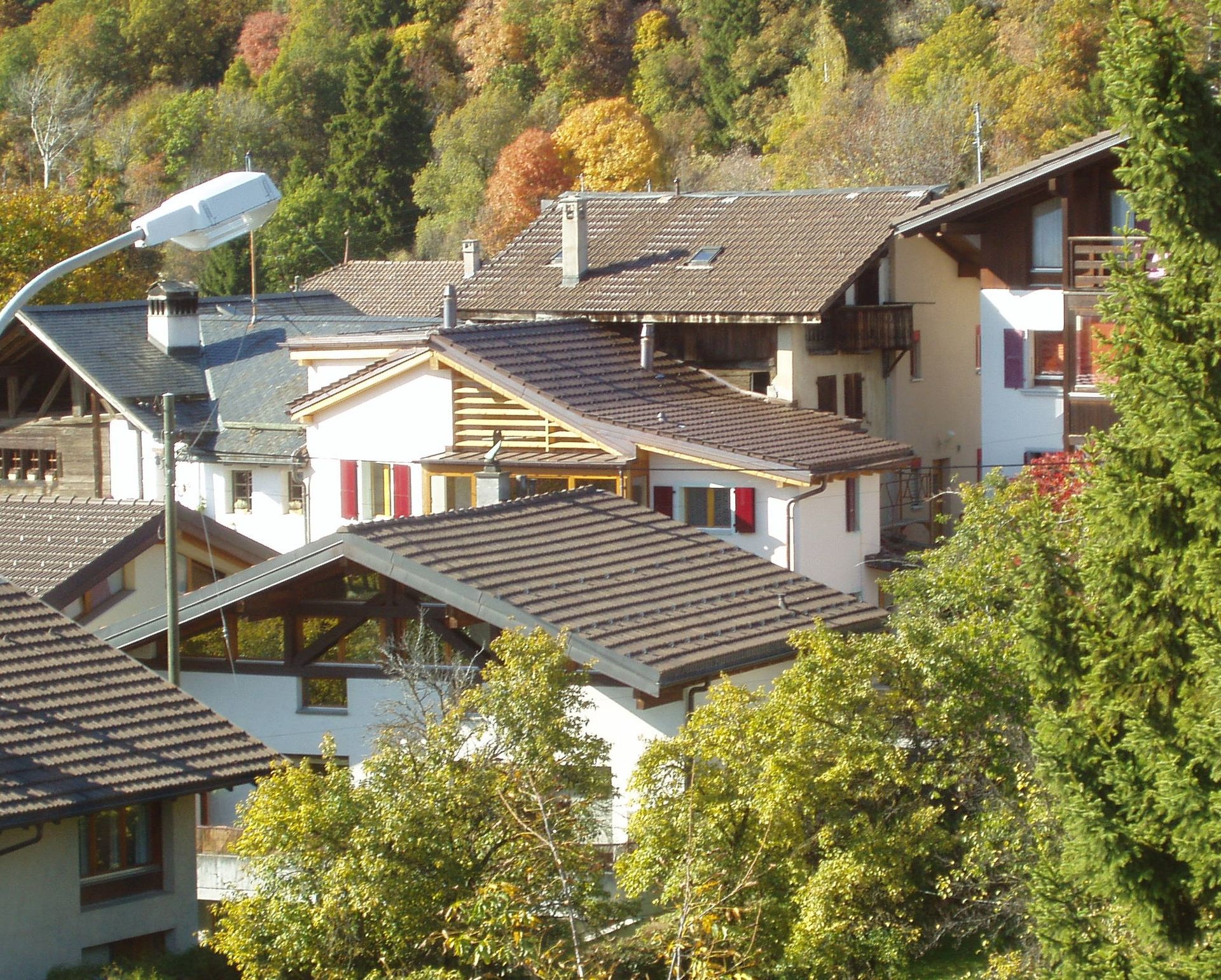 Une rangée de maisons sur une colline avec des arbres en arrière-plan