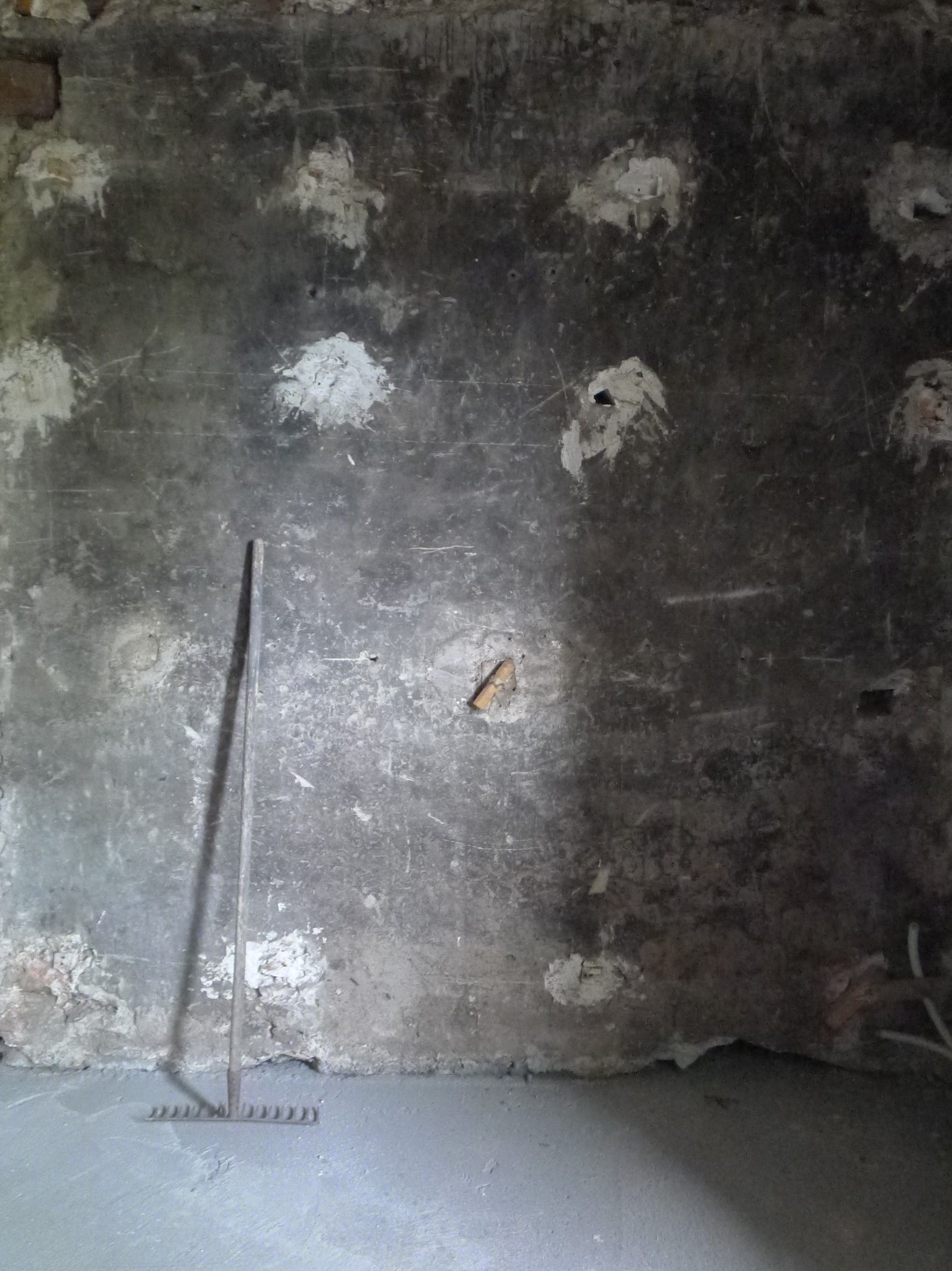 Un mur de béton avec un balai qui en sort.