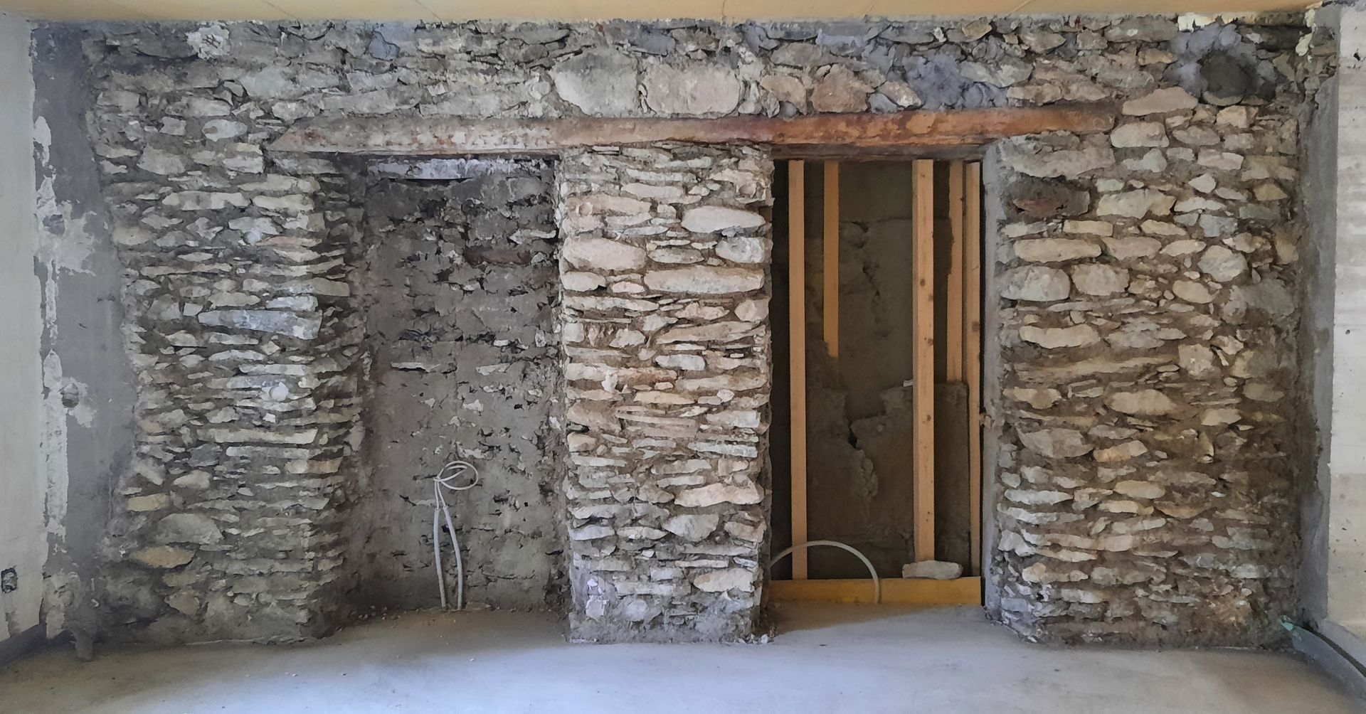 Une pièce avec un mur en pierre et une porte en bois