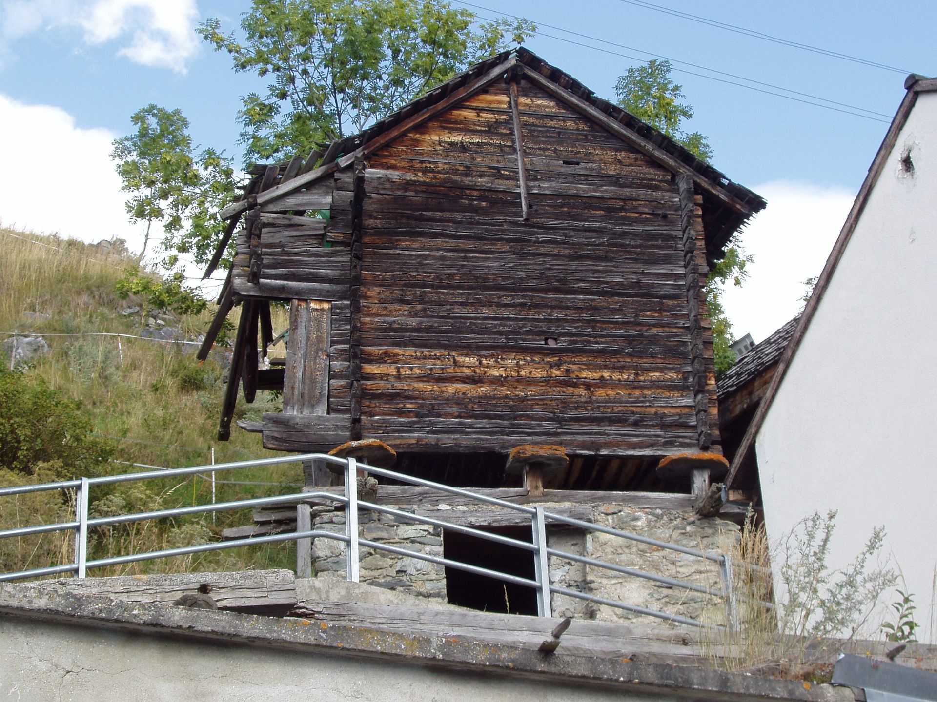 Un vieux bâtiment en bois avec une clôture en métal autour