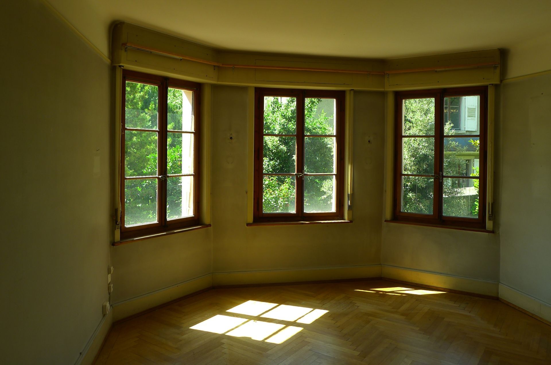 Une pièce avec beaucoup de fenêtres et un plancher en bois