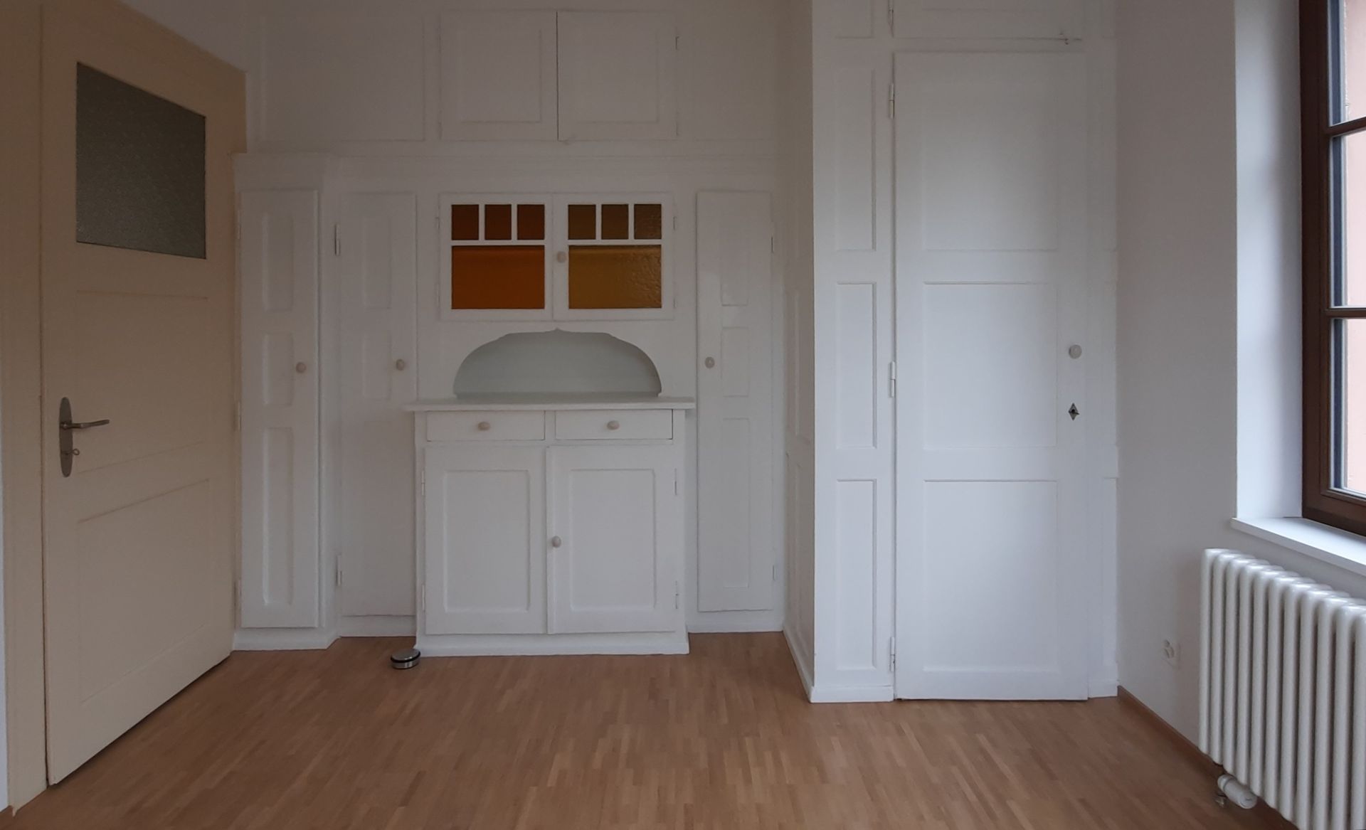 Une pièce vide avec une commode et une fenêtre