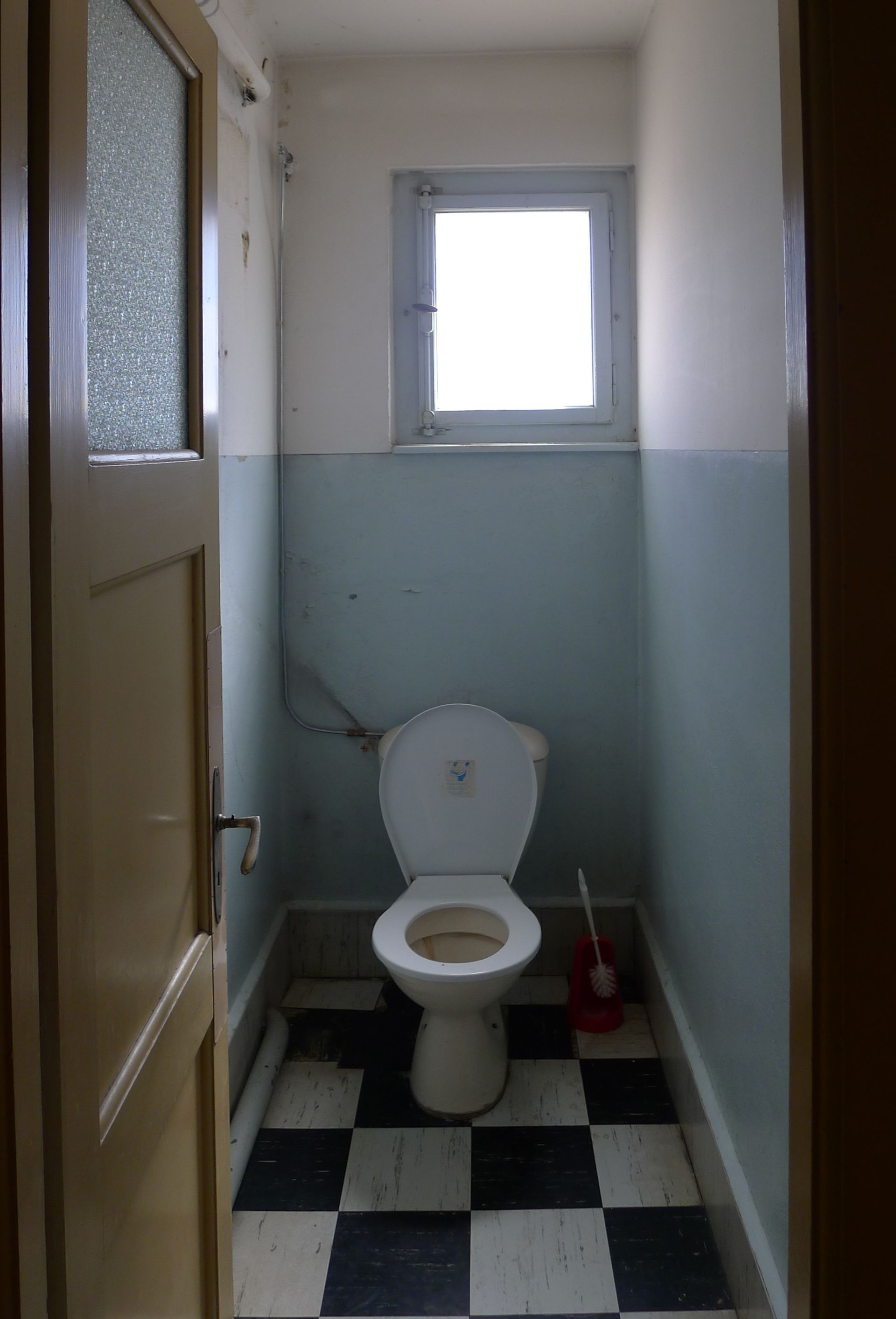 Une petite salle de bain avec toilettes et fenêtre