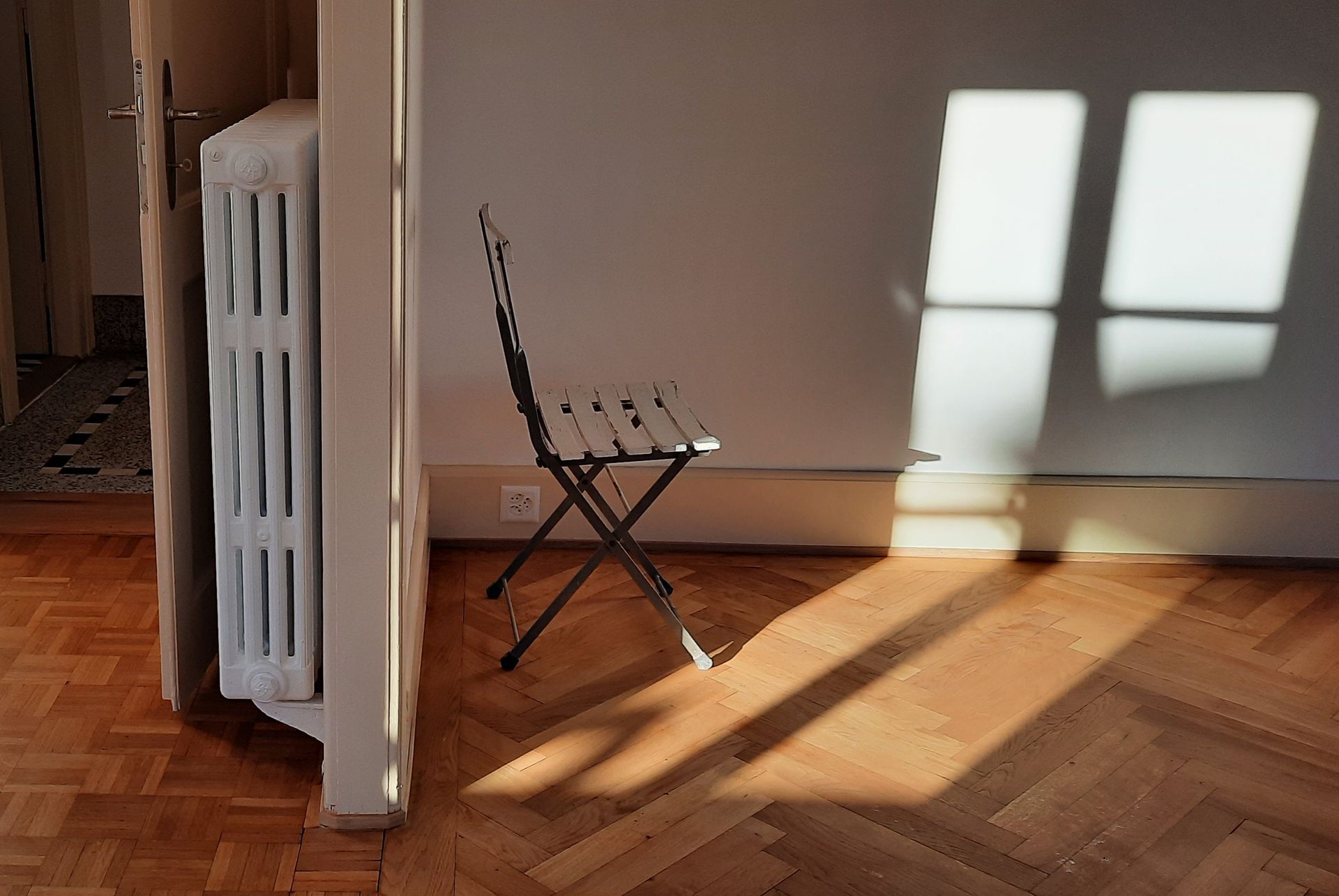 Une chaise est assise dans une pièce à côté d'un radiateur