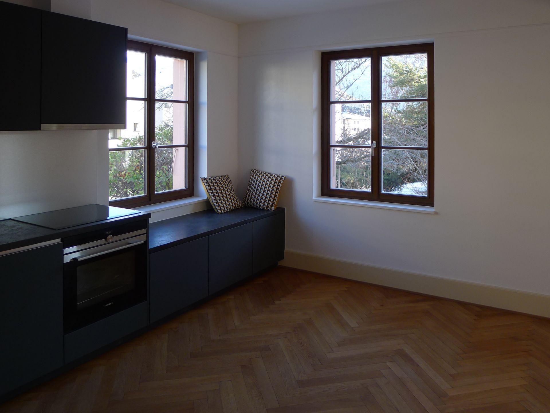 Une cuisine avec une fenêtre et un banc dans le coin.