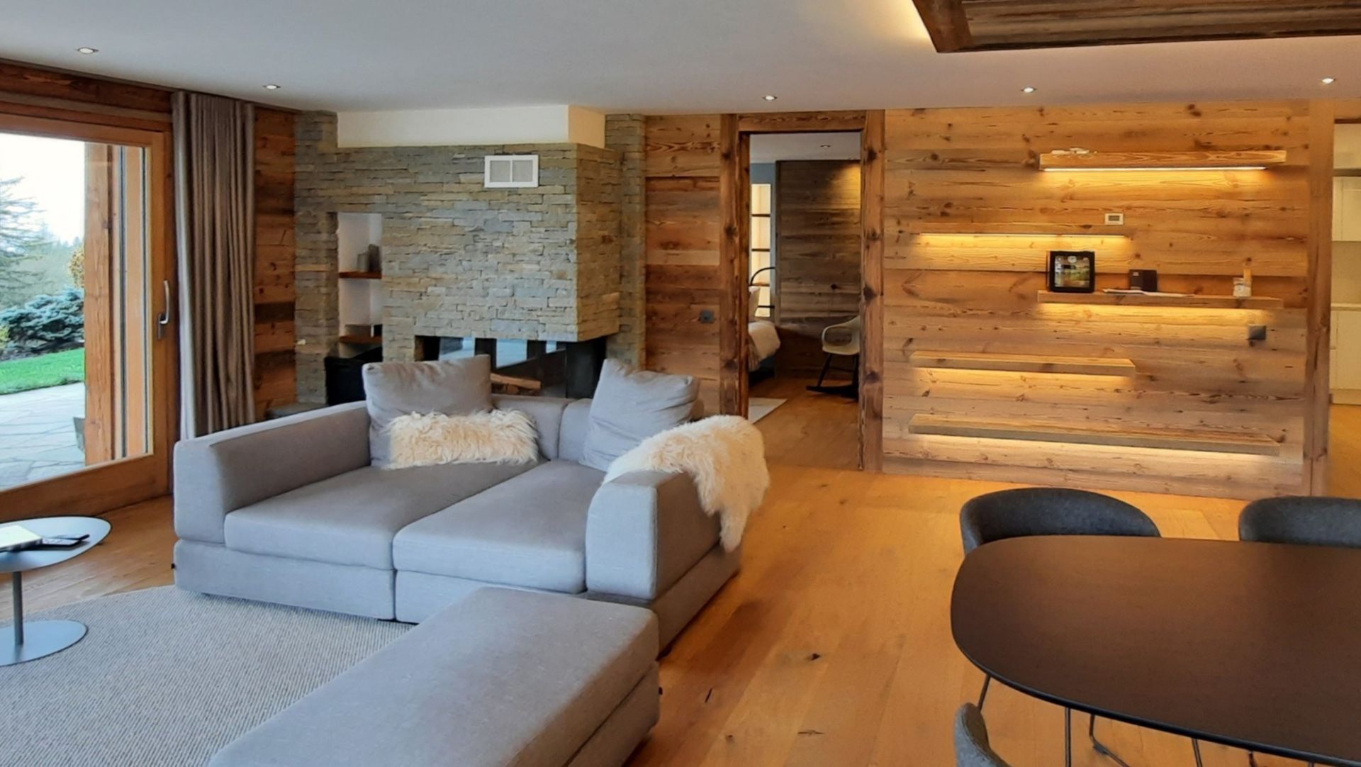 Un salon avec un canapé, une table, des chaises et une cheminée.