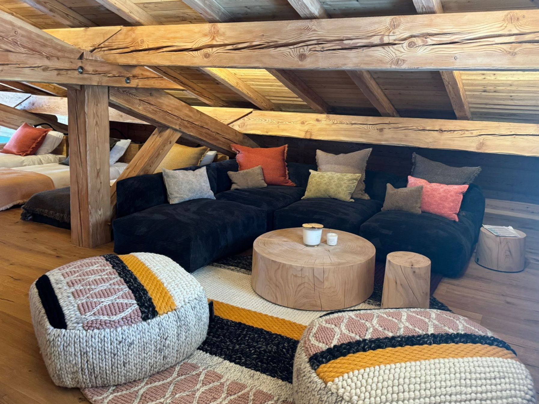 Un salon avec un canapé, des tables basses et des poufs.