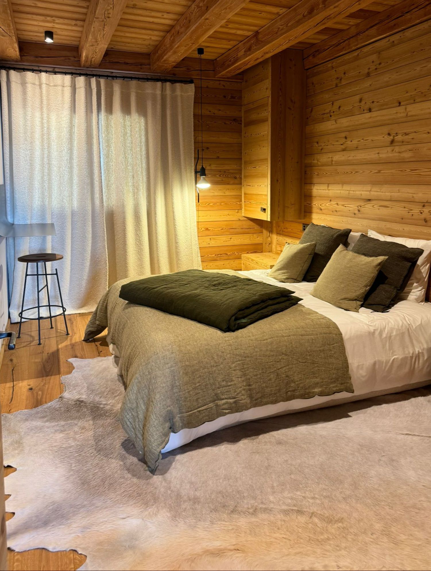 Une chambre avec un lit et un tapis dans une cabane en bois.