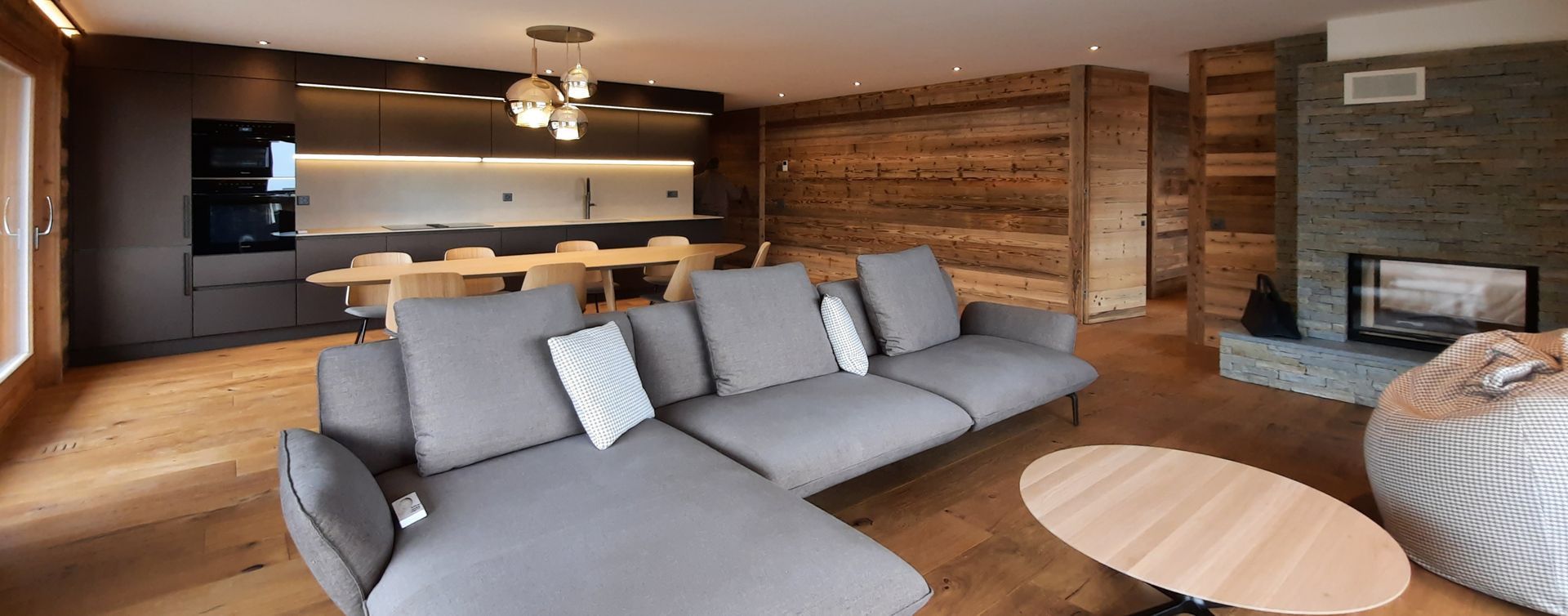 Un salon avec un canapé, une table et une cheminée.