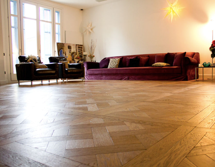 Una sala de estar con un sofá y sillas morados.