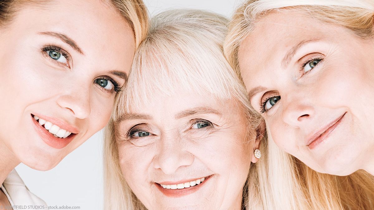 Drei Frauen posieren zusammen für ein Foto und lächeln.