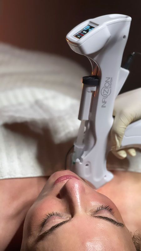 Eine Frau bekommt eine Gesichtsbehandlung mit einem Gerät.