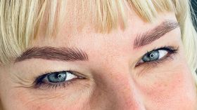 Eine Nahaufnahme des Gesichts einer Frau mit blonden Haaren und blauen Augen.