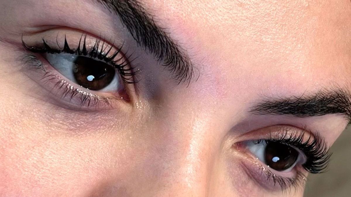 Zwei Frauen lächeln in die Kamera und schauen in die Kamera.