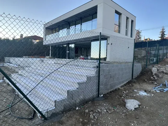 Una valla de alambre rodea una casa en construcción