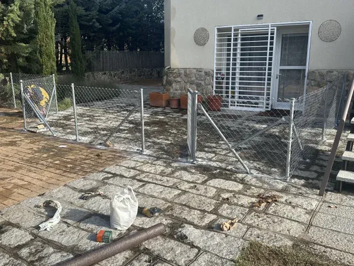 Se está construyendo una valla de alambre delante de una casa.